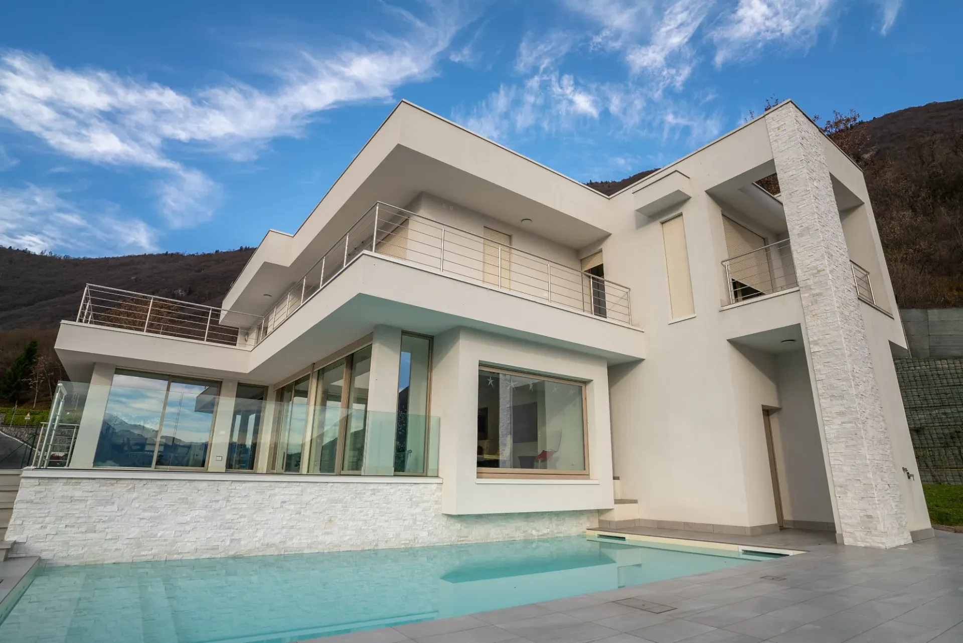 Piscina tradizionale davanti a una villa moderna